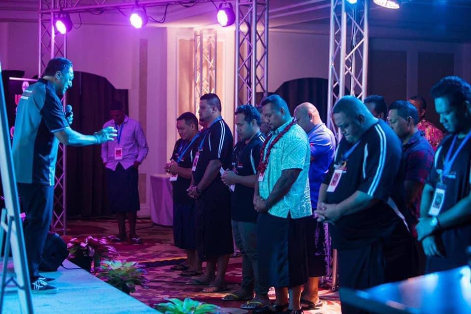 Lenny Solomona praying with delegates at the FITMAN Conference